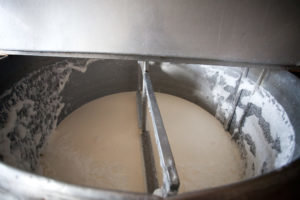 Σταδιακά προσθέτουμε το γάλα που έχει υποστεί ζύμωση ορού γάλακτος. Μετά την ανάμιξη το θρόμβωμα περιεχομένων. 